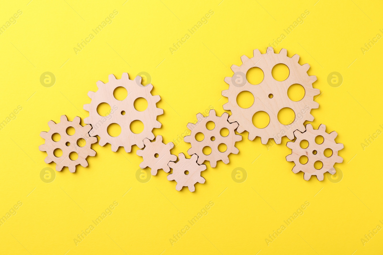 Photo of Business process organization and optimization. Scheme with wooden figures on yellow background, top view