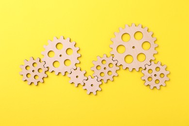 Business process organization and optimization. Scheme with wooden figures on yellow background, top view