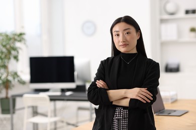 Photo of Portrait of beautiful businesswoman with crossed arms in office. Space for text