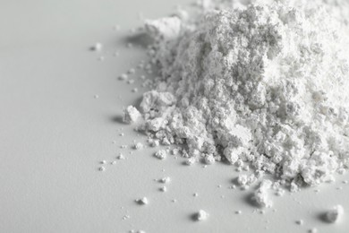 Photo of Heap of calcium carbonate powder on white table, closeup