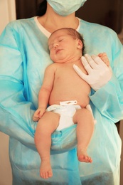 Doctor holding cute newborn child in hospital