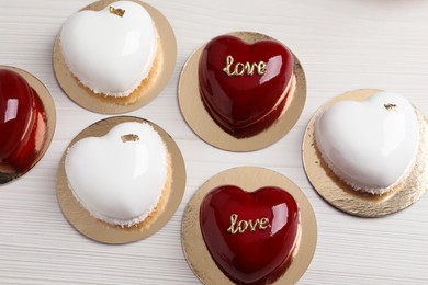 Photo of St. Valentine's Day. Delicious heart shaped cakes on white wooden table, flat lay