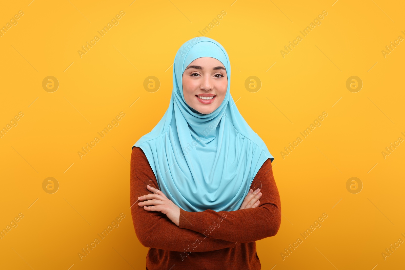 Photo of Portrait of Muslim woman in hijab on orange background