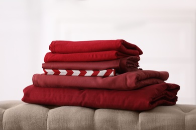 Stack of new clean folded bed linens on bench