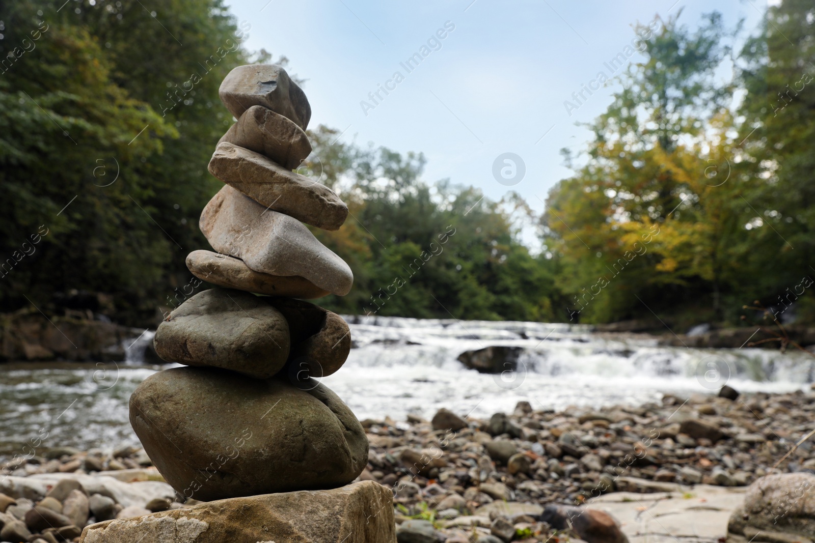 Photo of Stack of stones on pebble coast near river