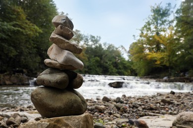 Photo of Stack of stones on pebble coast near river