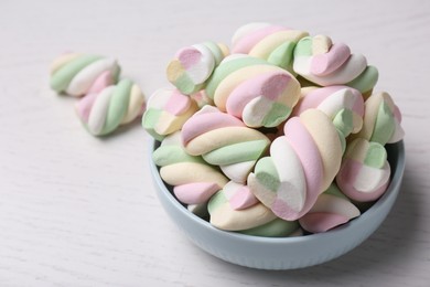 Bowl with colorful marshmallows on white table, closeup. Space for text