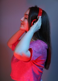 Photo of Portrait of beautiful woman with headphones on color background