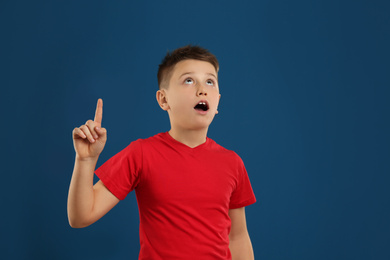 Portrait of emotional preteen boy on blue background