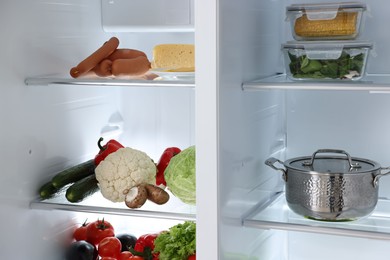 Open refrigerator full of different products indoors