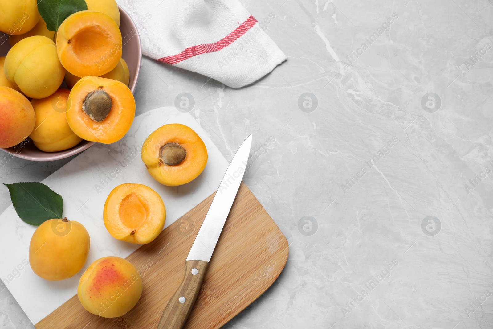 Photo of Delicious fresh ripe apricots on grey marble table, flat lay. Space for text