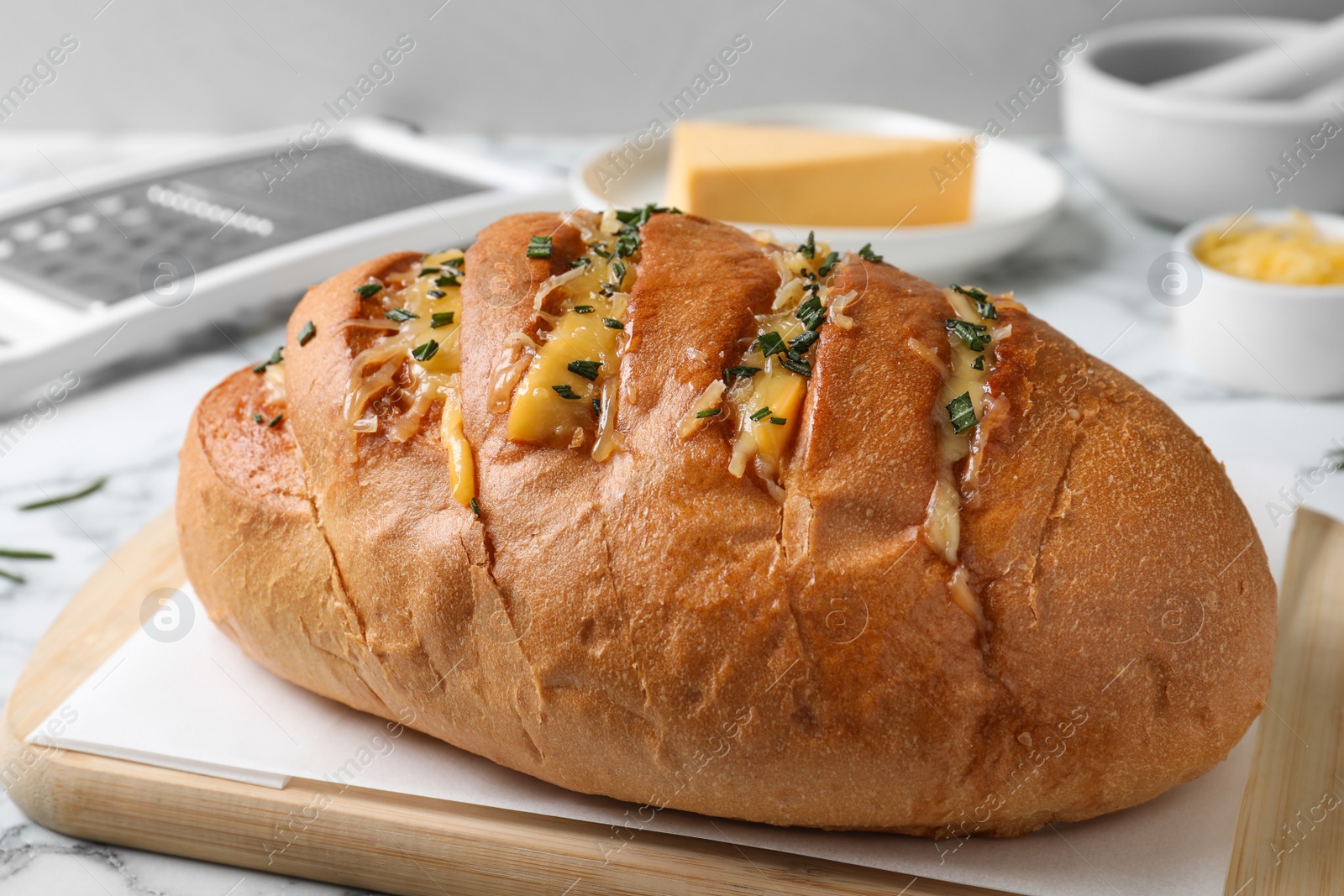 Photo of Delicious homemade garlic bread with herbs and cheese on table, closeup