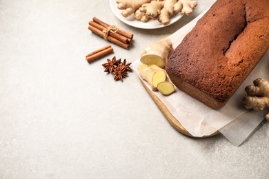 Photo of Delicious gingerbread cake and ingredients on light grey table, above view. Space for text