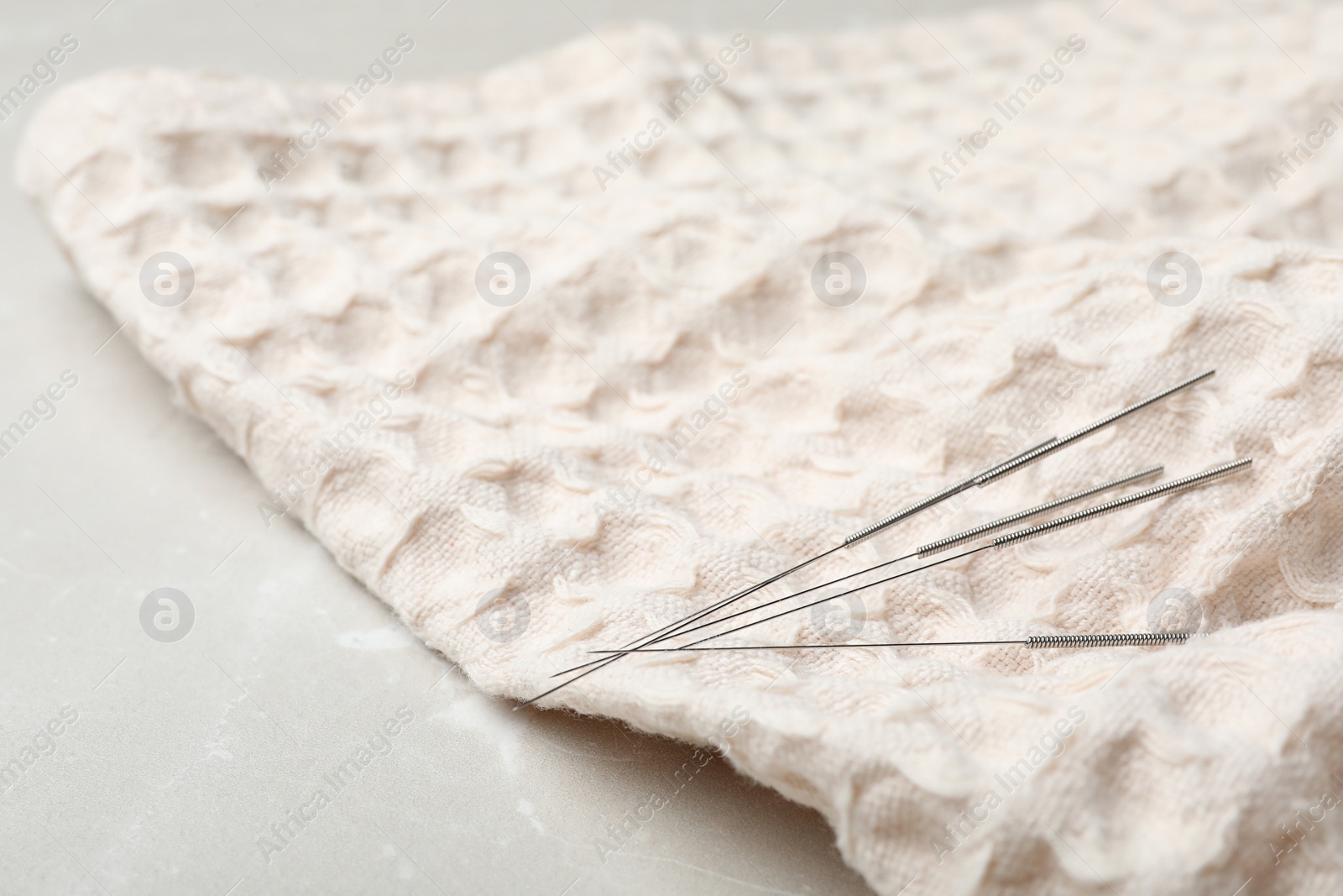 Photo of Acupuncture needles on towel, closeup. Alternative medicine