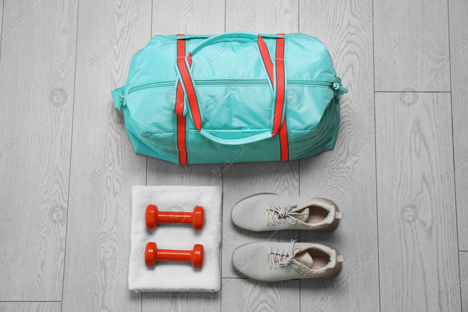 Photo of Bag and different sports equipment on wooden floor, flat lay