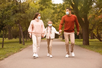 Lovely family walking together in park during coronavirus pandemic