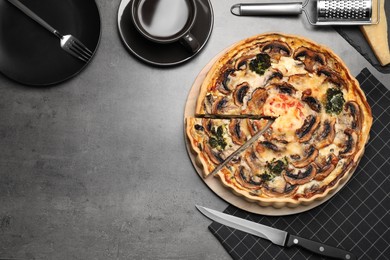 Photo of Delicious quiche with mushrooms served on dark grey table, flat lay. Space for text