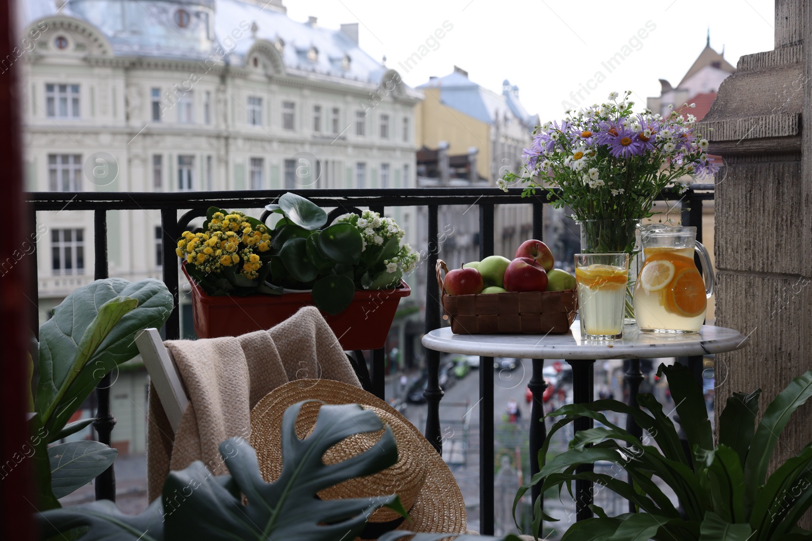 Photo of Relaxing atmosphere. Stylish furniture surrounded by beautiful houseplants on balcony