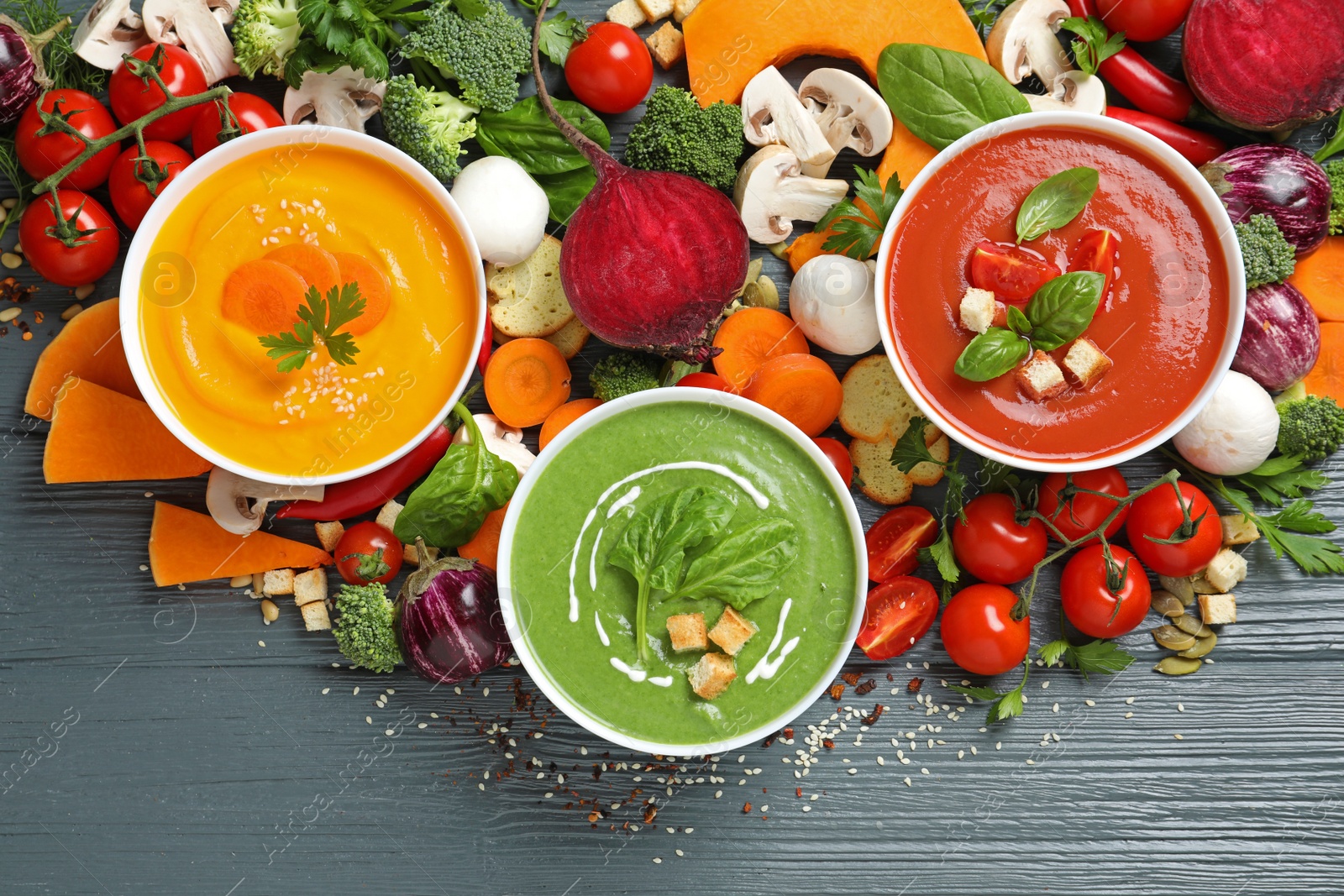 Photo of Various cream soups and ingredients on wooden background, flat lay. Healthy food