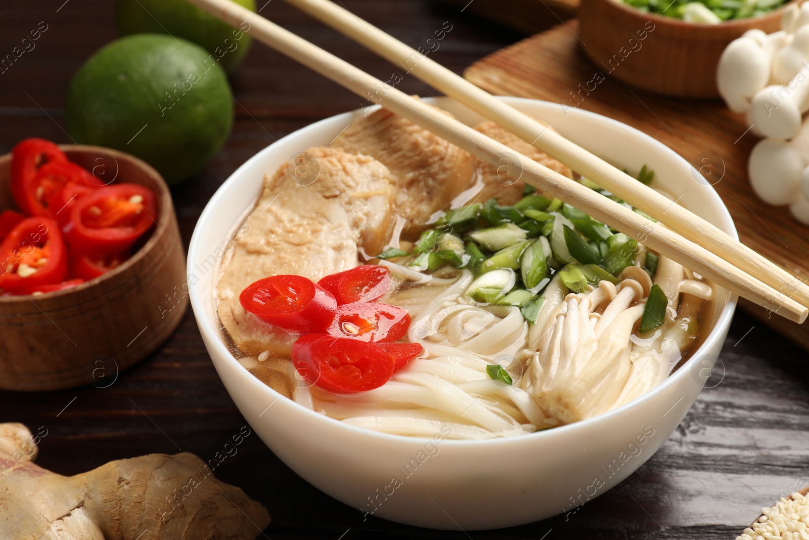 Photo of Delicious ramen with meat and ingredients on wooden table, closeup. Noodle soup