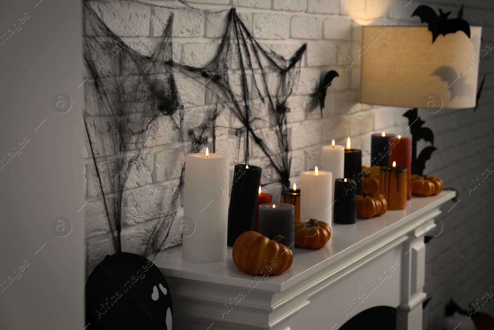 Photo of Fireplace with different Halloween decor indoors. Festive interior