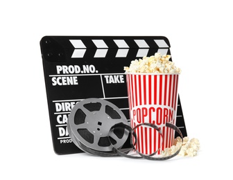 Photo of Popcorn, clapper and reel isolated on white. Cinema snack