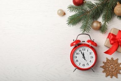 Flat lay composition with alarm clock and festive decor on wooden background. Christmas countdown