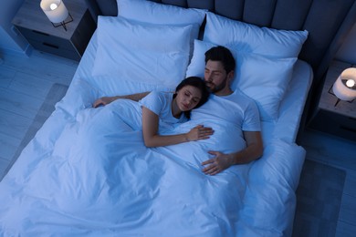 Lovely couple sleeping together in bed at night, top view