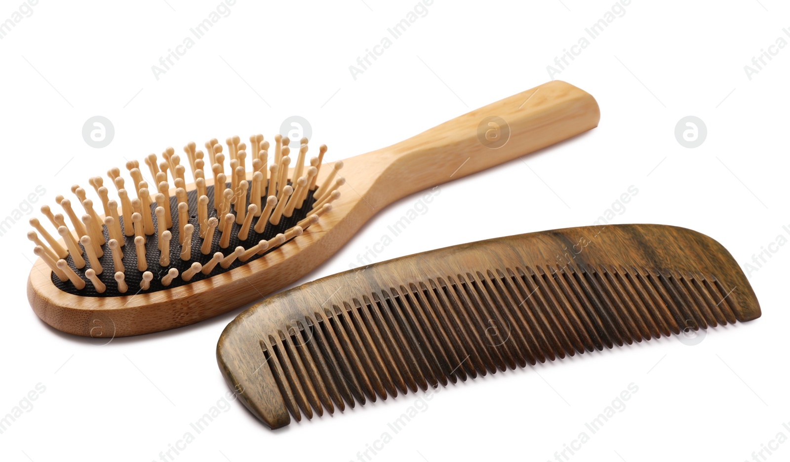 Photo of New wooden hair brush and comb on isolated white