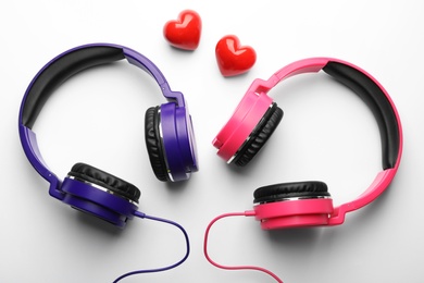 Photo of Decorative hearts and modern headphones on white background, top view