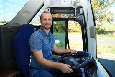 Photo of Professional bus driver at steering wheel. Passenger transportation