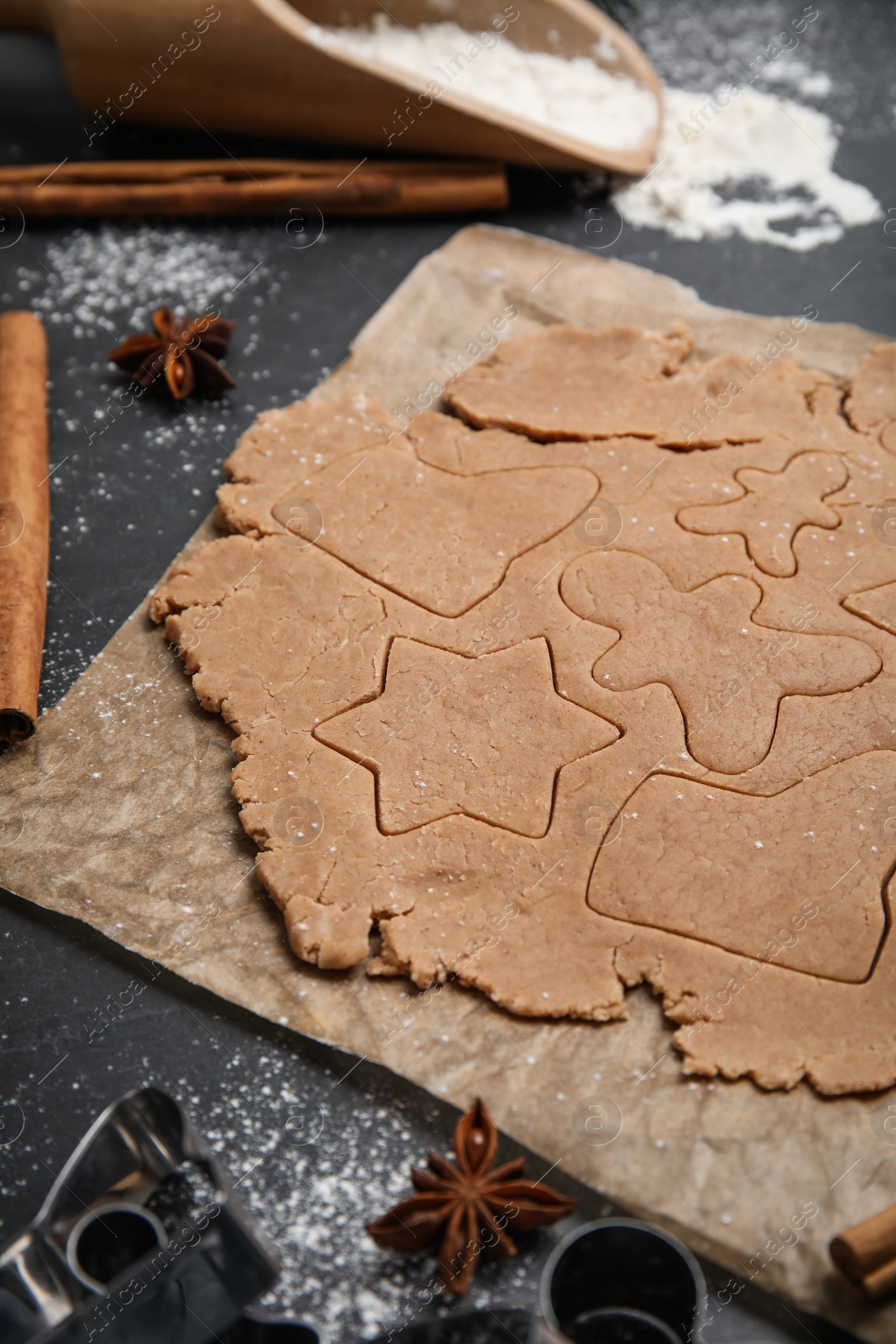 Photo of Making Christmas cookies. Raw dough and anise on black table, closeup