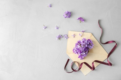 Flat lay composition with beautiful blossoming lilac on light background. Spring flowers