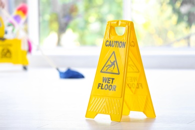 Safety sign with phrase Caution wet floor, indoors. Cleaning service