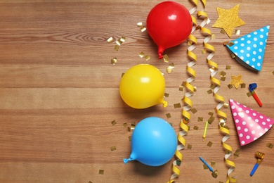 Photo of Flat lay composition with party decor and air balloons on wooden background