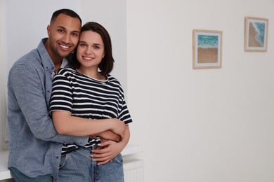 Dating agency. Couple hugging near window at home, space for text