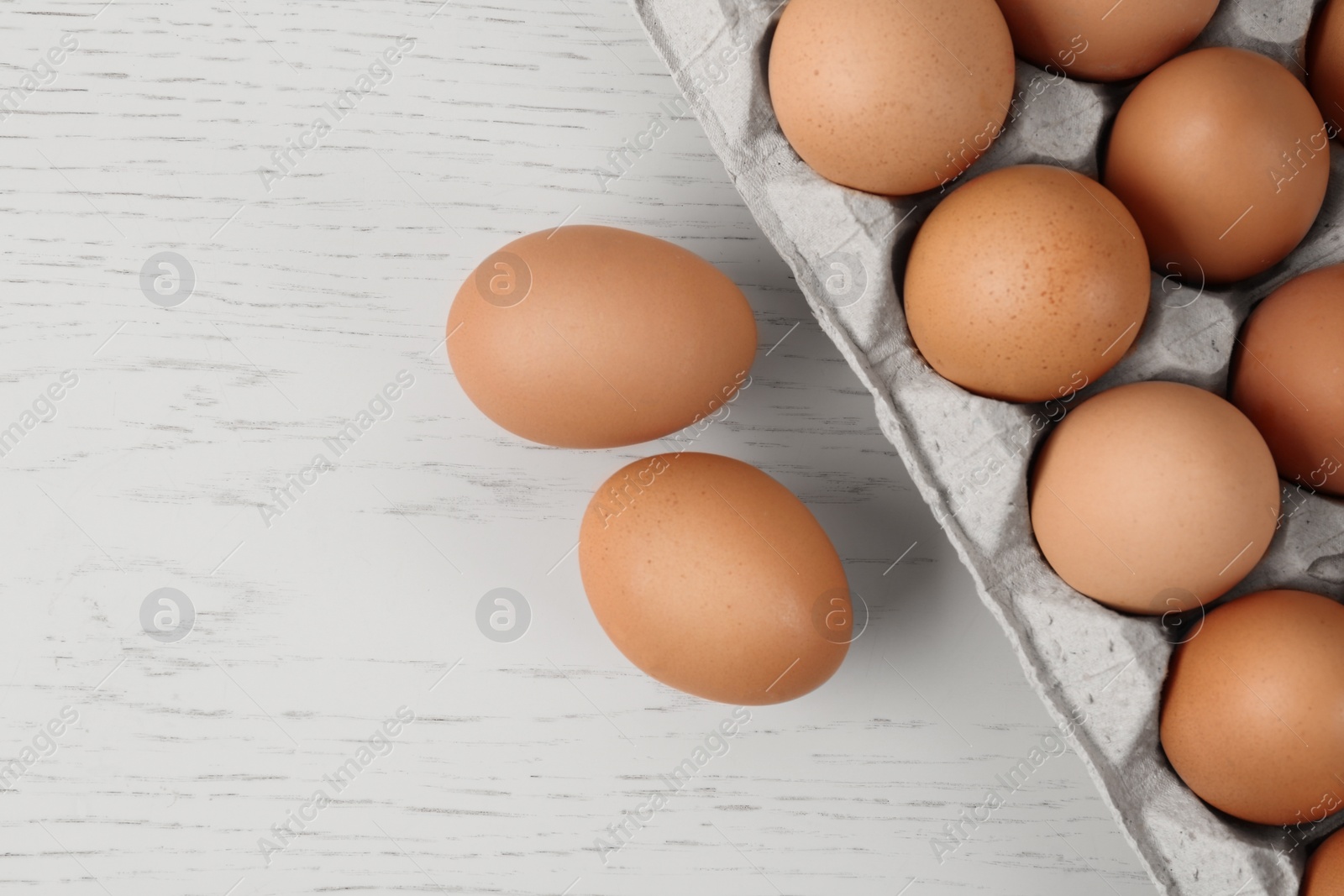 Photo of Raw chicken eggs on white wooden table, flat lay