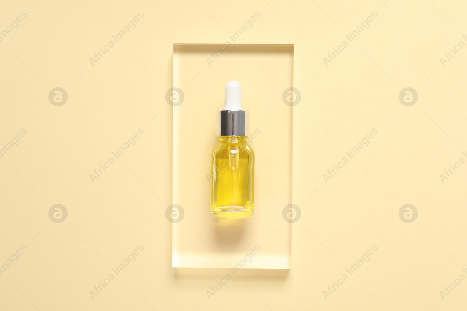 Photo of Bottle of cosmetic serum on beige background, top view