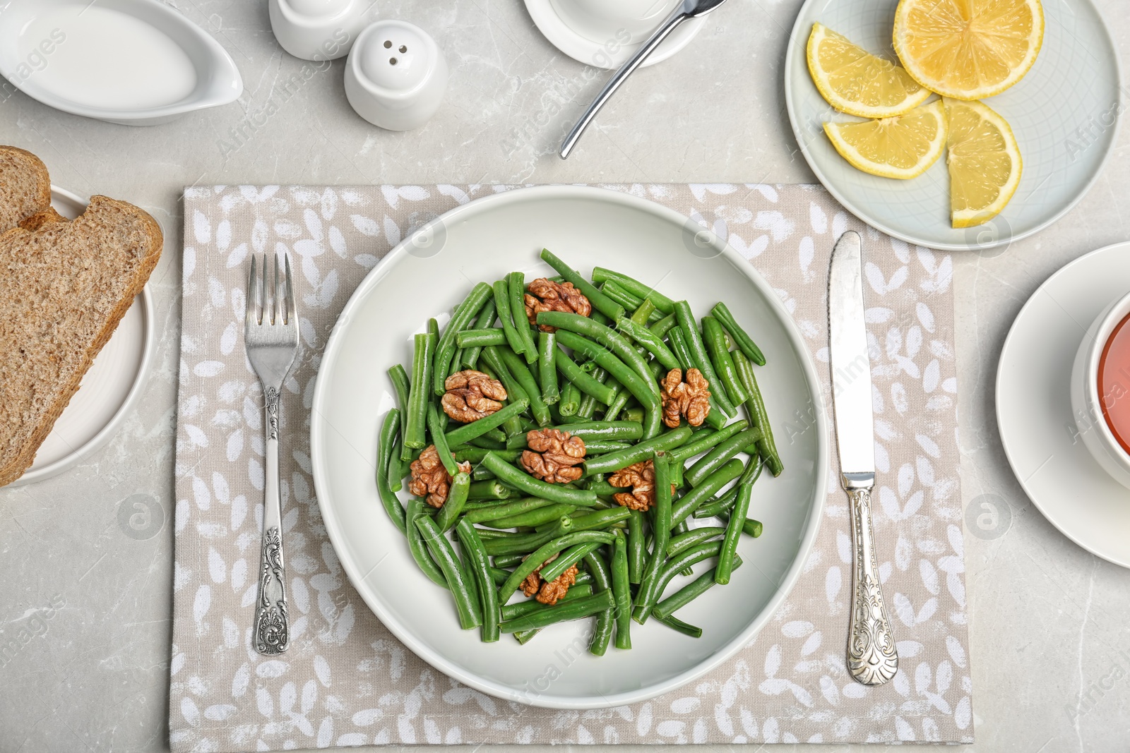 Photo of Flat lay composition with plate of fresh green bean salad on table