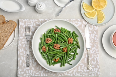 Photo of Flat lay composition with plate of fresh green bean salad on table