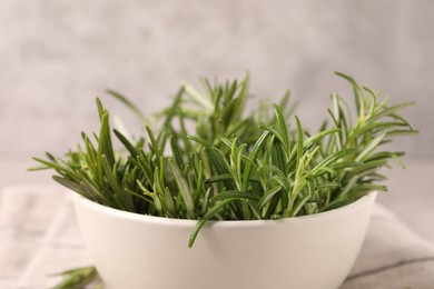 Photo of Bowl with fresh green rosemary against blurred background, closeup