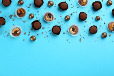 Photo of Different delicious chocolate candies on light blue background, flat lay. Space for text