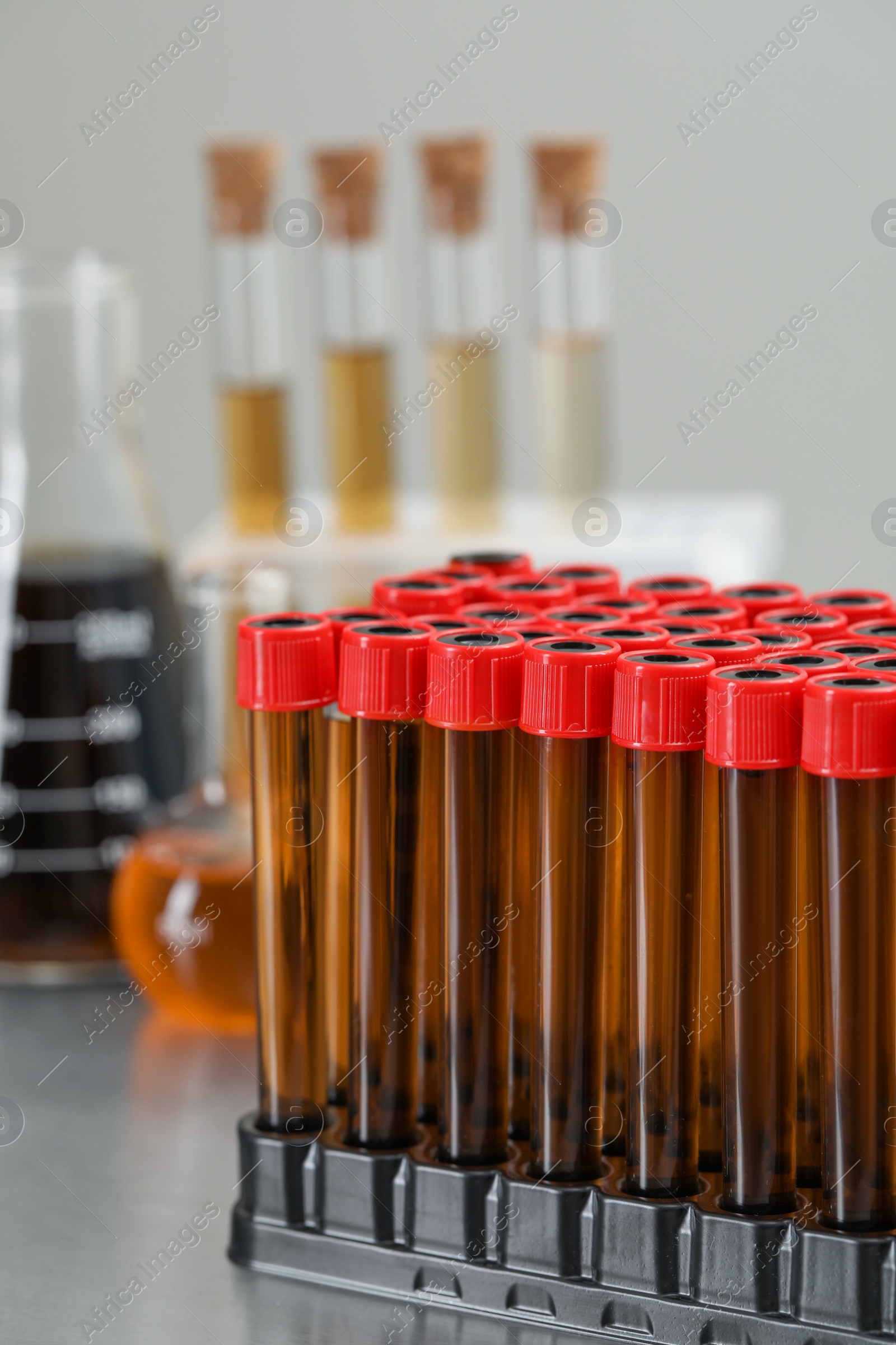 Photo of Test tubes with brown liquid in stand on table