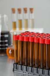 Photo of Test tubes with brown liquid in stand on table