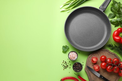 Photo of Flat lay composition with frying pan and fresh products on green background, space for text