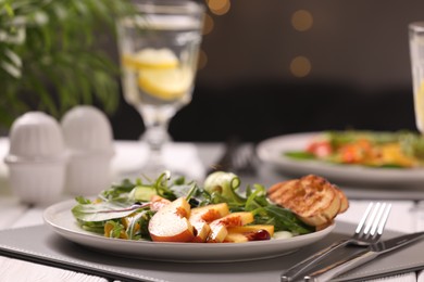 Photo of Delicious salad with peach slices served on table