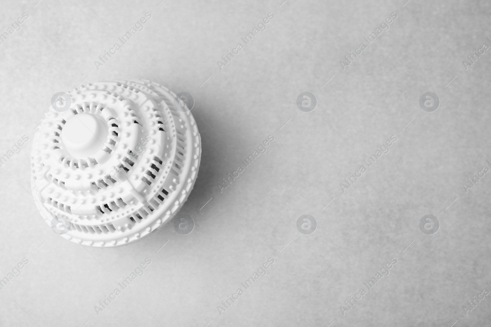 Photo of Laundry dryer ball on light grey table, top view. Space for text