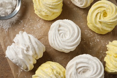 Photo of Many delicious yellow and white marshmallows on parchment paper, flat lay