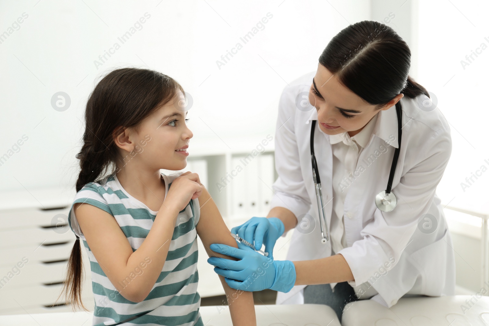 Photo of Doctor vaccinating little child in modern clinic