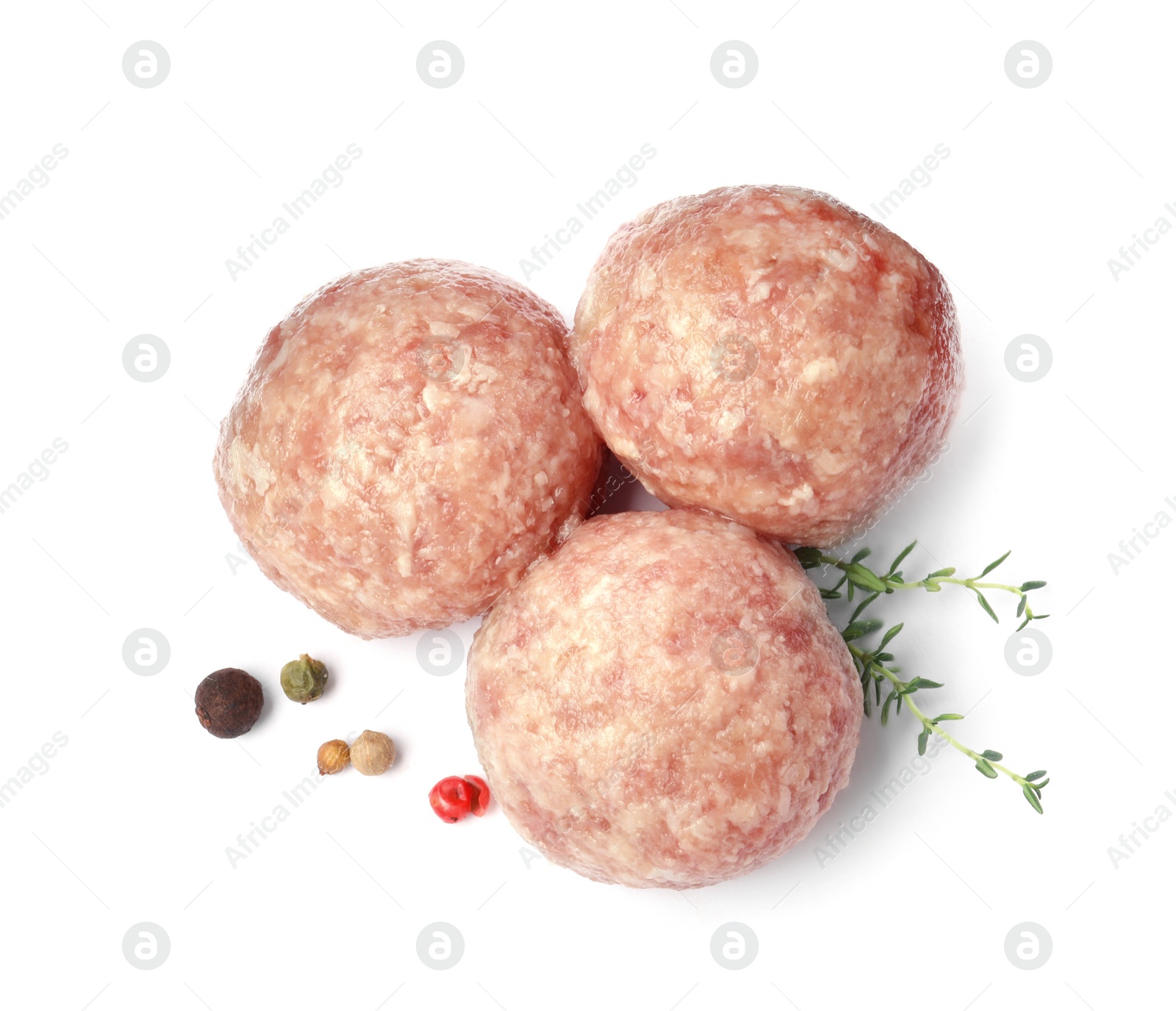 Photo of Three fresh raw meatballs with thyme and spices on white background, top view